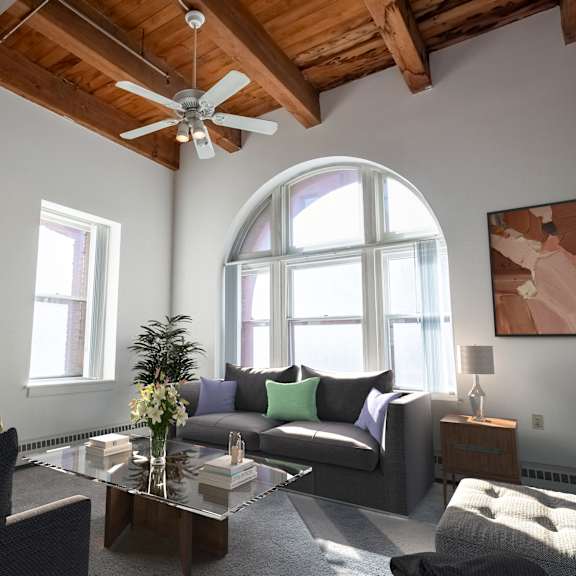 a living room with a ceiling fan and a large window