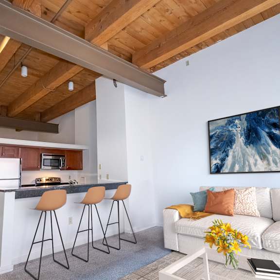 a kitchen with a bar and a living room with a couch