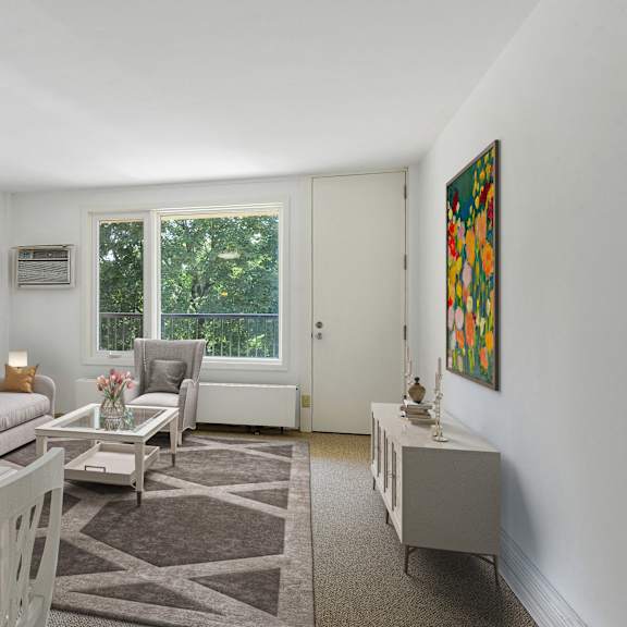 a living room with a couch and a table and a window at humboldt senior 55+ apartments, saint paul
