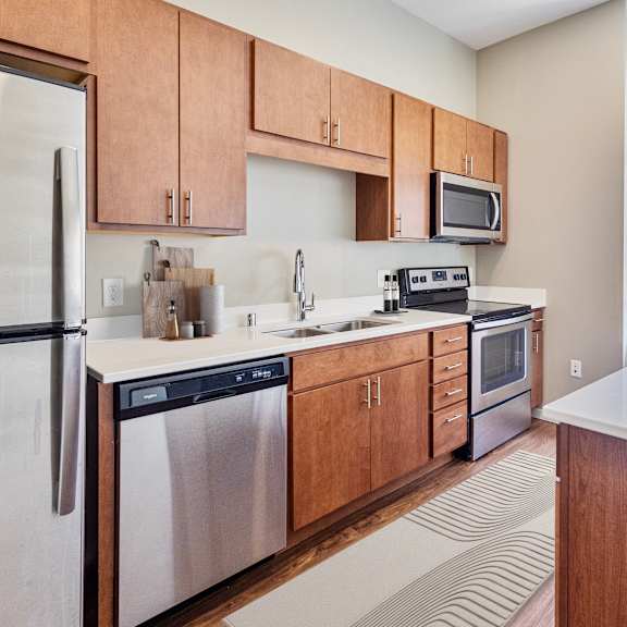 a kitchen with wooden cabinets and stainless steel appliances and a window at press house apartments, st paul, 55101