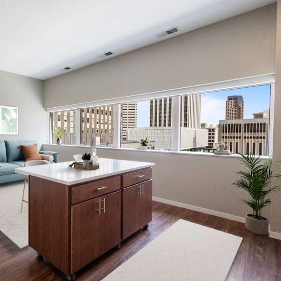 a living room with a kitchen and a large window at press house apartments, st paul, mn, 55101