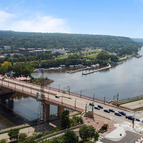 an aerial view of a bridge over a river and a city at press house apartments, minnesota
