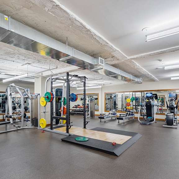 a gym with weights and other exercise equipment in a building at press house apartments, st paul, minnesota