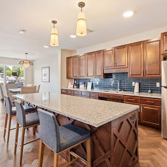 a kitchen with a large island and a stainless steel refrigerator at the quill 55+ apartments, minnesota, 55033