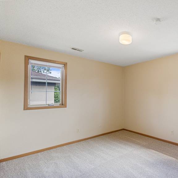 a room with two windows and carpeted flooring at ames lake neighborhood apartments, minnesota