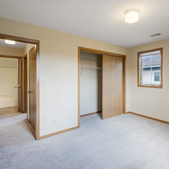 a room with a carpeted floor and a window with a picture frame hanging on the wall at ames lake neighborhood apartments, st paul 55106