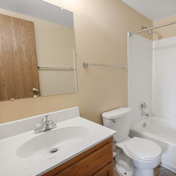 a white toilet sits next to a white sink in a bathroom at ames lake neighborhood apartments, st paul, mn, 55106