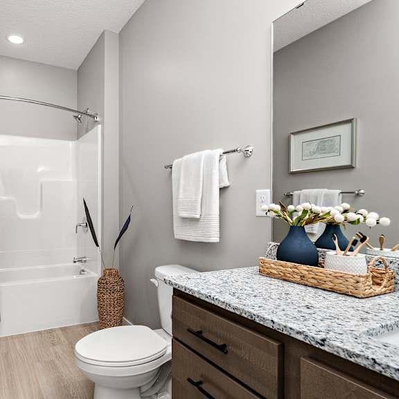 a bathroom with a toilet, sink, and shower.