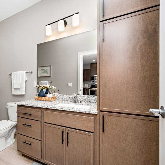 a bathroom with a toilet, sink, and shower.