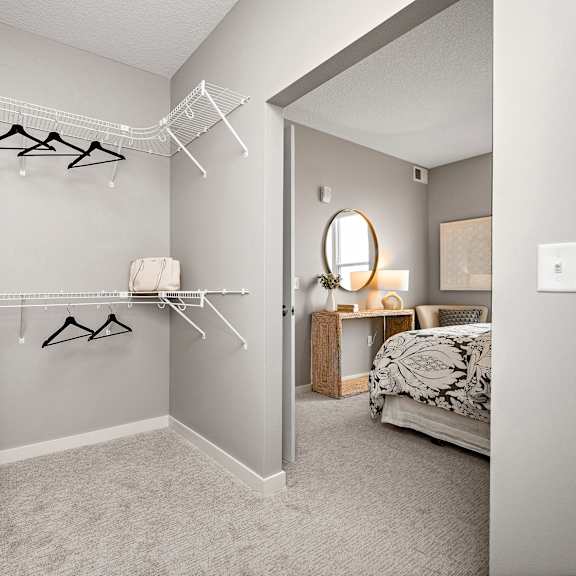 walk-in closet with organized shelving and hanging rods at reserve at settlers ridge apartments, minnesota, 55129