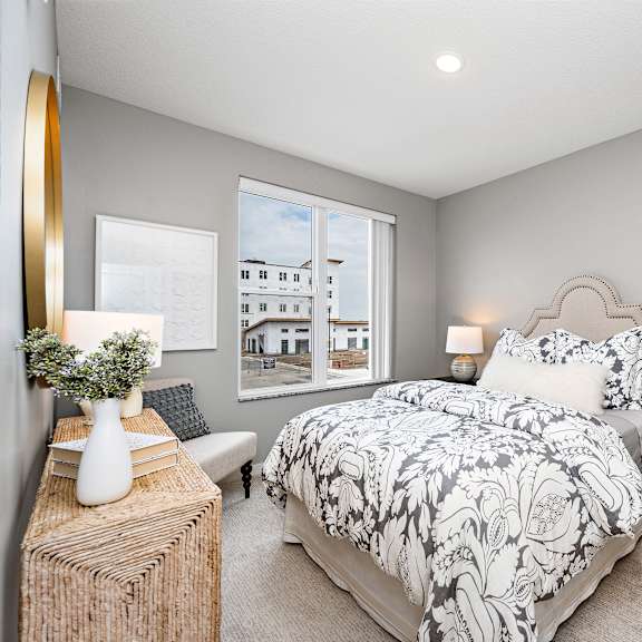 a bedroom with a large bed and a window overlooking a building.