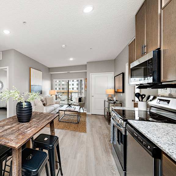 a modern kitchen with a wooden table and bar stools.