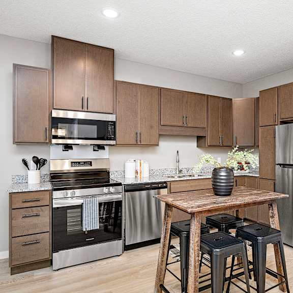 modern kitchen with stainless steel appliances and island at reserve at settlers ridge apartments, woodbury, mn 55129