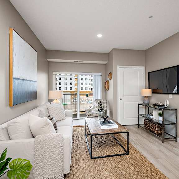 a living room with a white couch and a painting on the wall.