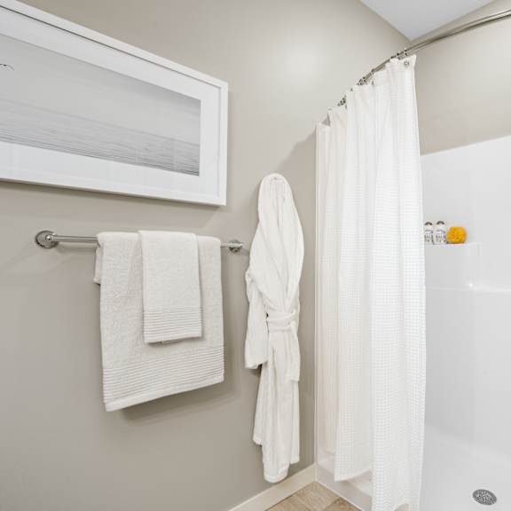 a white bathroom with a white tub and a white shower curtain.