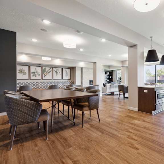 a modern dining room with a wooden table and chairs at sonder point 50+ apartments, brooklyn center, mn, 55430