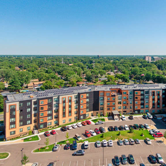 a large apartment complex with a parking lot in front at sonder point 50+ apartments, brooklyn center, mn