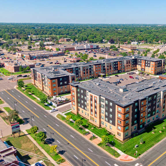 an aerial view of an apartment complex with a large building with a gray roof at sonder point 50+ apartments, brooklyn center, minnesota