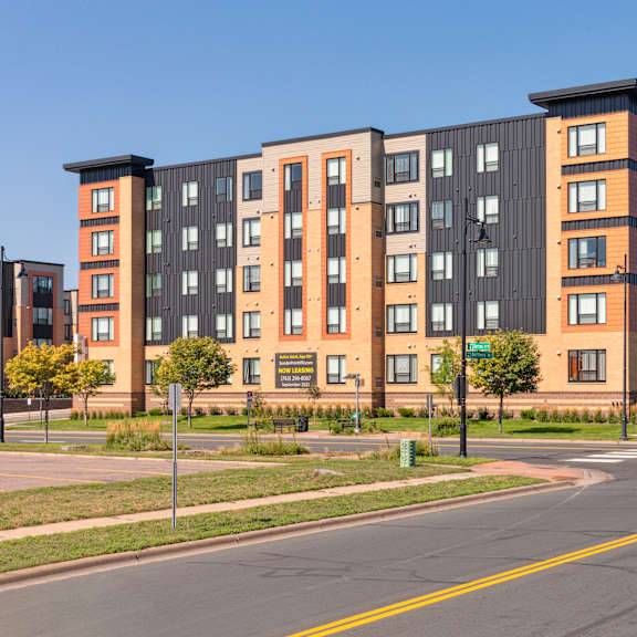 a large apartment building with a black and orange facade at sonder point 50+ apartments, brooklyn center, minnesota
