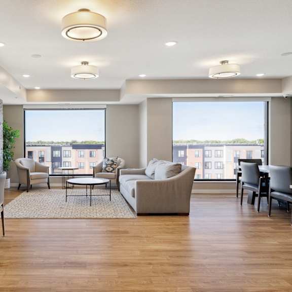 a spacious living room with a dining table and chairs at sonder point 50+ apartments, brooklyn center, 55430