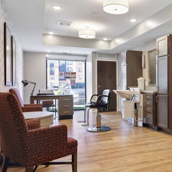 a room with a desk, chairs and a lamp at sonder point 50+ apartments, minnesota