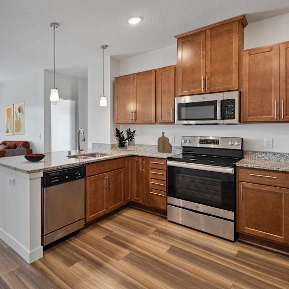 an open kitchen and living room with wooden floors and wooden cabinets
