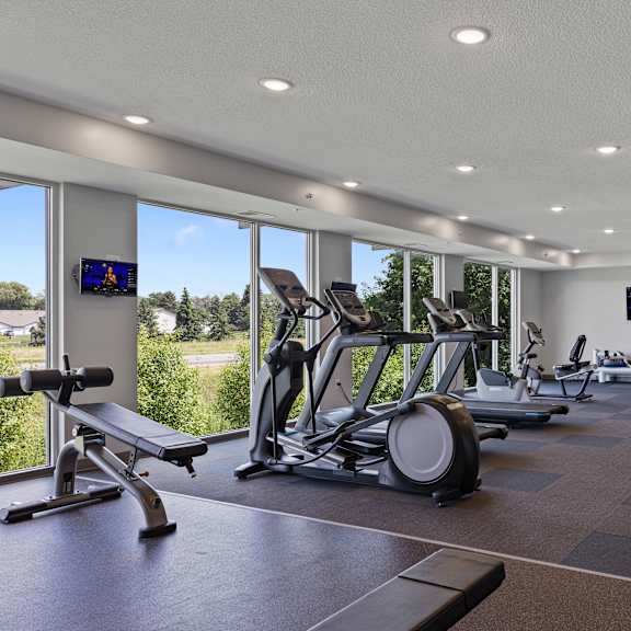 a gym with treadmills and other exercise equipment and windows