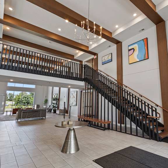 the entryway of a house with a staircase and a table in the center