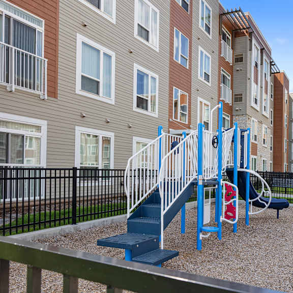 a blue playground in front of an apartment building