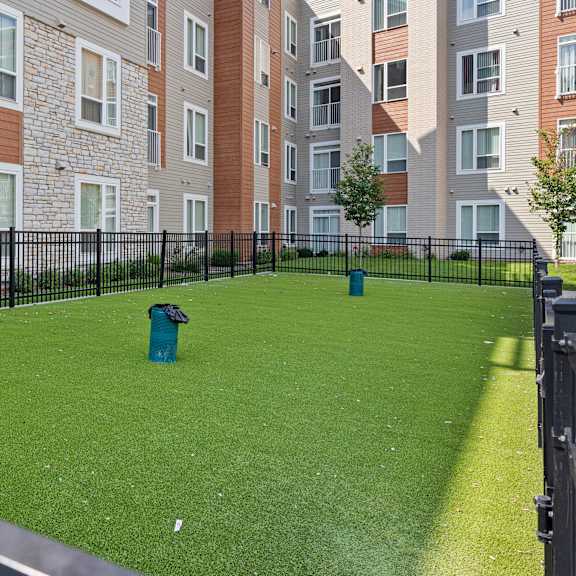 a yard with a fire hydrant in front of an apartment building