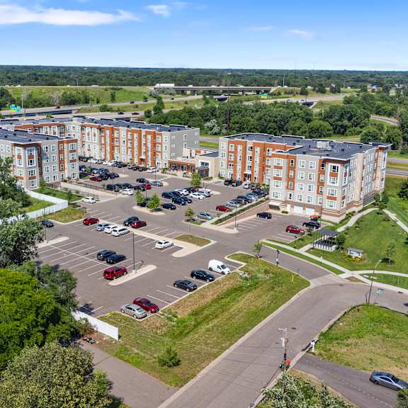 an aerial view of a parking lot in front of several apartment buildings