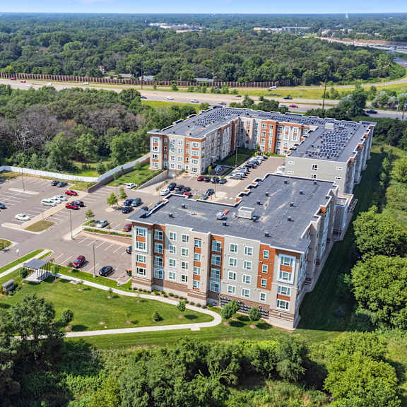 an aerial view of an apartment building next to a highway