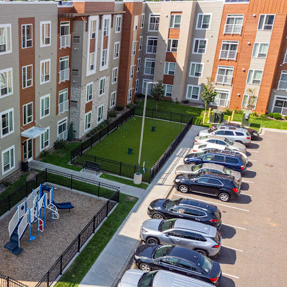 an aerial view of an apartment building with cars parked in a parking lot