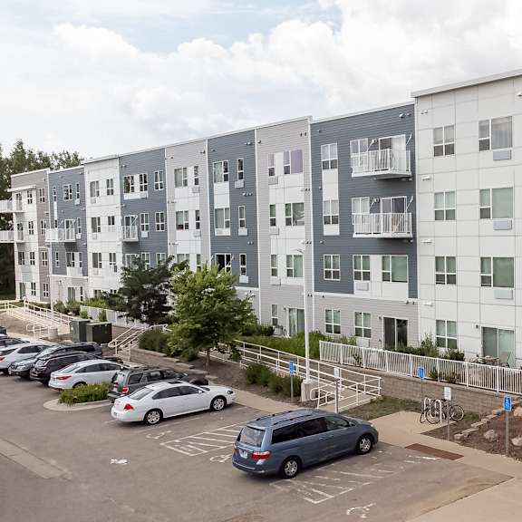 an image of an apartment building with cars parked in a parking lot at technology park apartments, rochester, 55901
