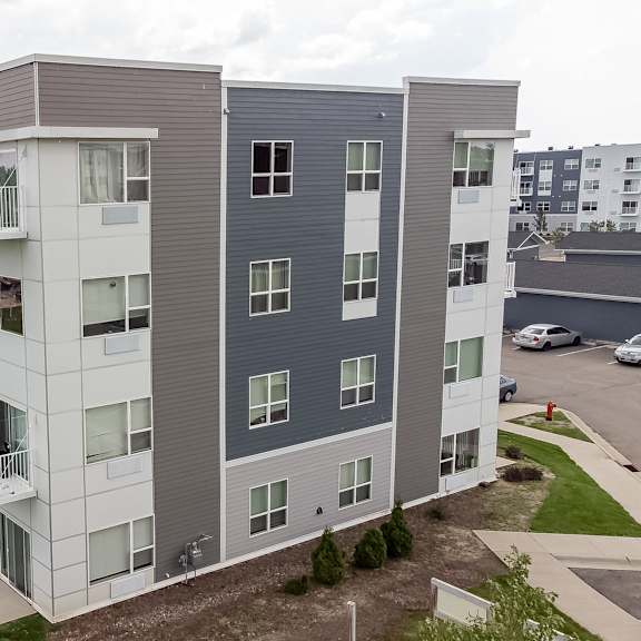 an aerial view of an apartment building with green grass and a parking lot at technology park apartments, rochester, mn, 55901