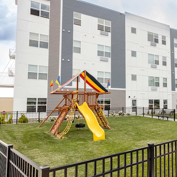 a playground in the middle of an apartment building with a slide at technology park apartments, minnesota