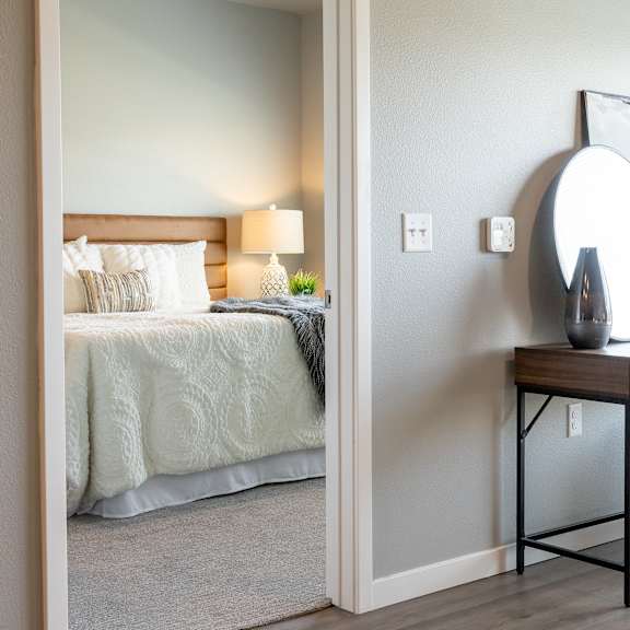 a bedroom with a bed and a nightstand and a mirror at technology park apartments, rochester