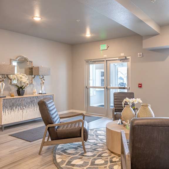 a living room with chairs and a table and a fireplace at technology park apartments, rochester, mn, 55901