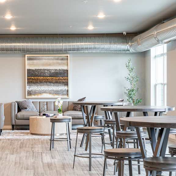 a communal area with tables and chairs in a living room at technology park apartments, rochester, mn, 55901