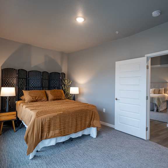 a bedroom with a bed and a door to a bathroom at technology park apartments, minnesota