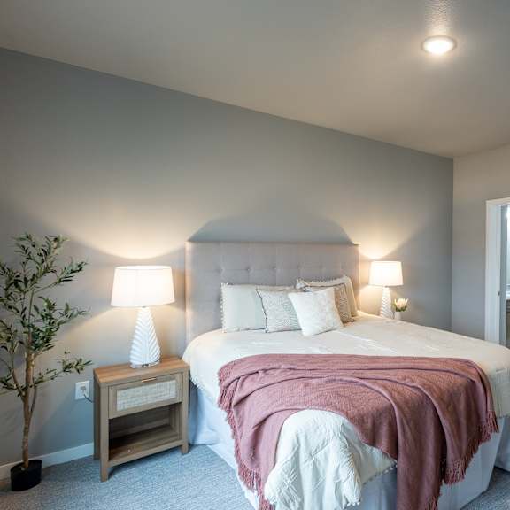a bedroom with a large bed and a door to a bathroom at technology park apartments, rochester, minnesota