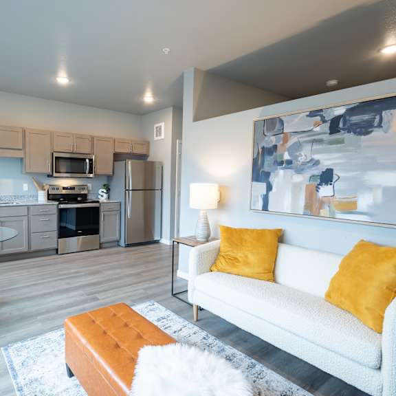 a living room with a couch and a table and a kitchen at technology park apartments, minnesota