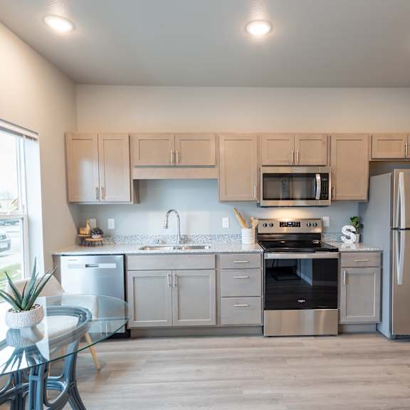 a kitchen with stainless steel appliances and white cabinets at technology park apartments, rochester, minnesota