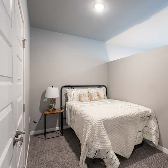 a bedroom with a small bed and a white closet at technology park apartments, minnesota, 55901