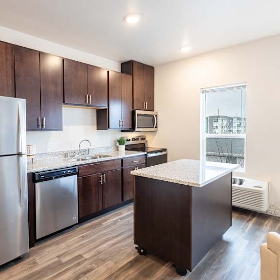 a kitchen with stainless steel appliances and wooden cabinets at technology park apartments, rochester, mn