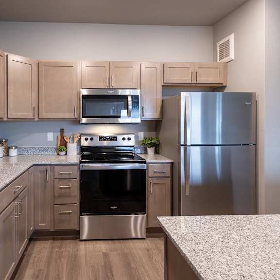 a kitchen with granite counter tops and stainless steel appliances at technology park apartments, rochester, 55901