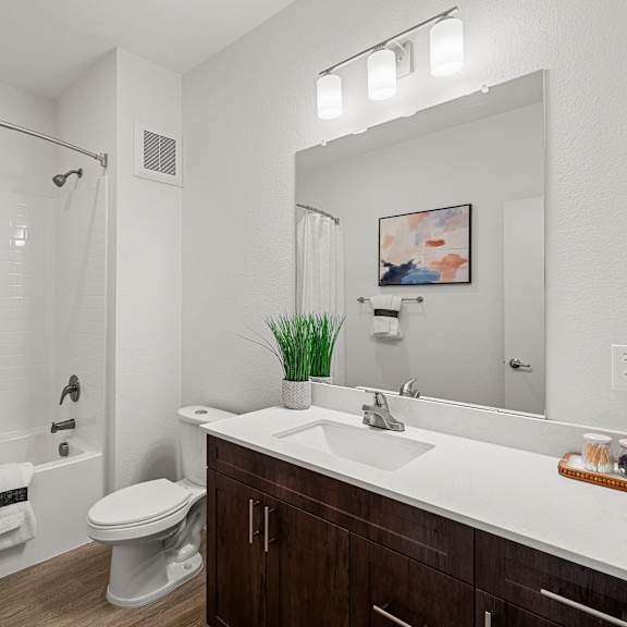 a white bathroom with a toilet, sink, and shower.