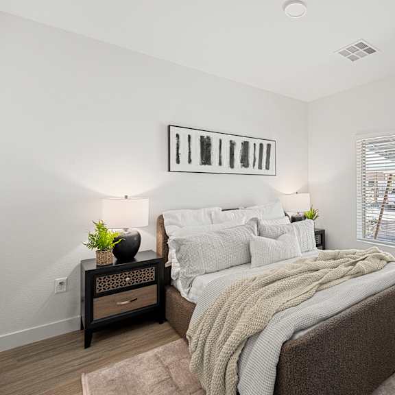 a bedroom with a large bed and a window with blinds.
