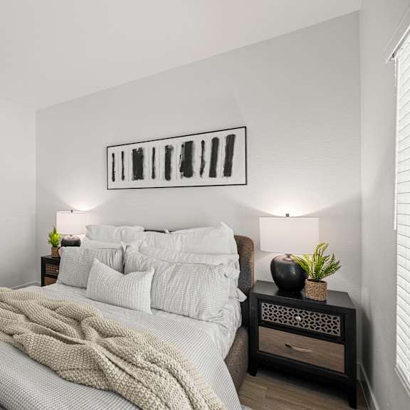 a bedroom with a bed, nightstand, and a painting on the wall.