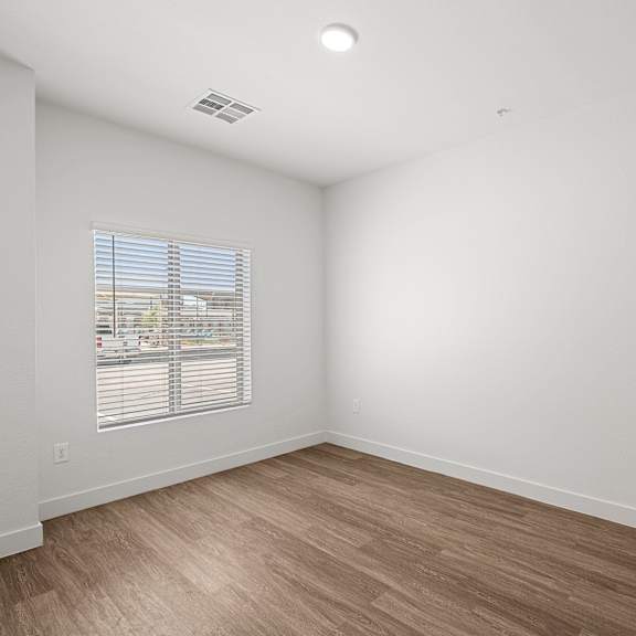 a room with a window and wooden flooring.
